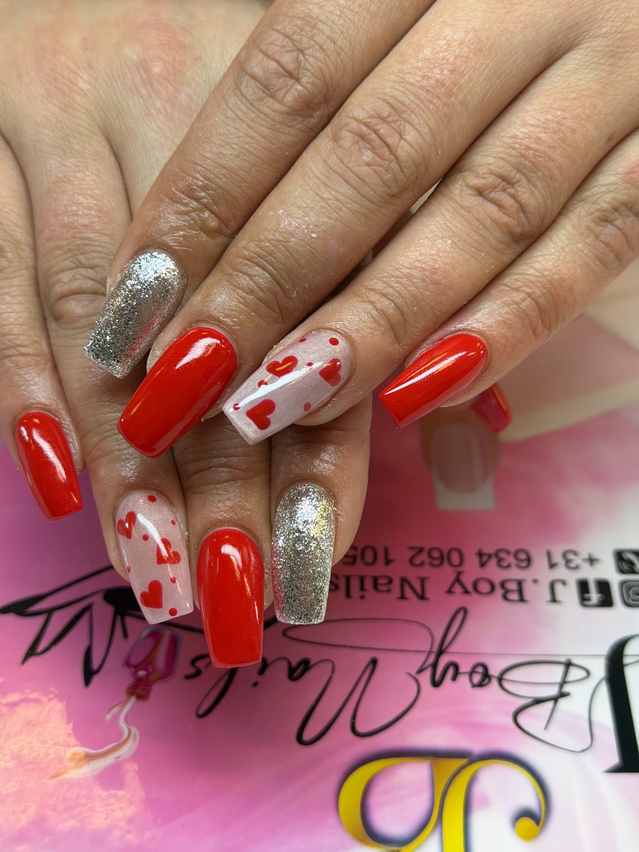 Rode en zilveren glitternagels met hartjes op de roze J.Boy Nails mat