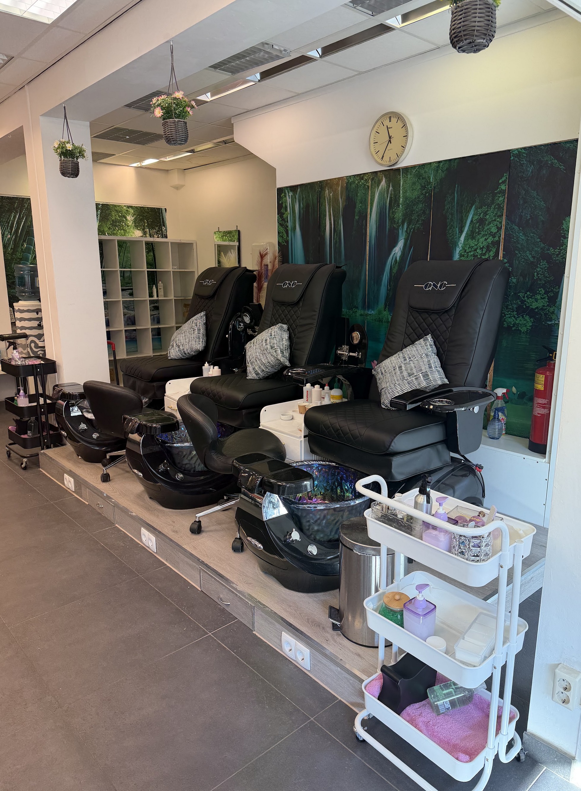 Twee zwarte pedicure-massagestoelen met voetbaden in de studio